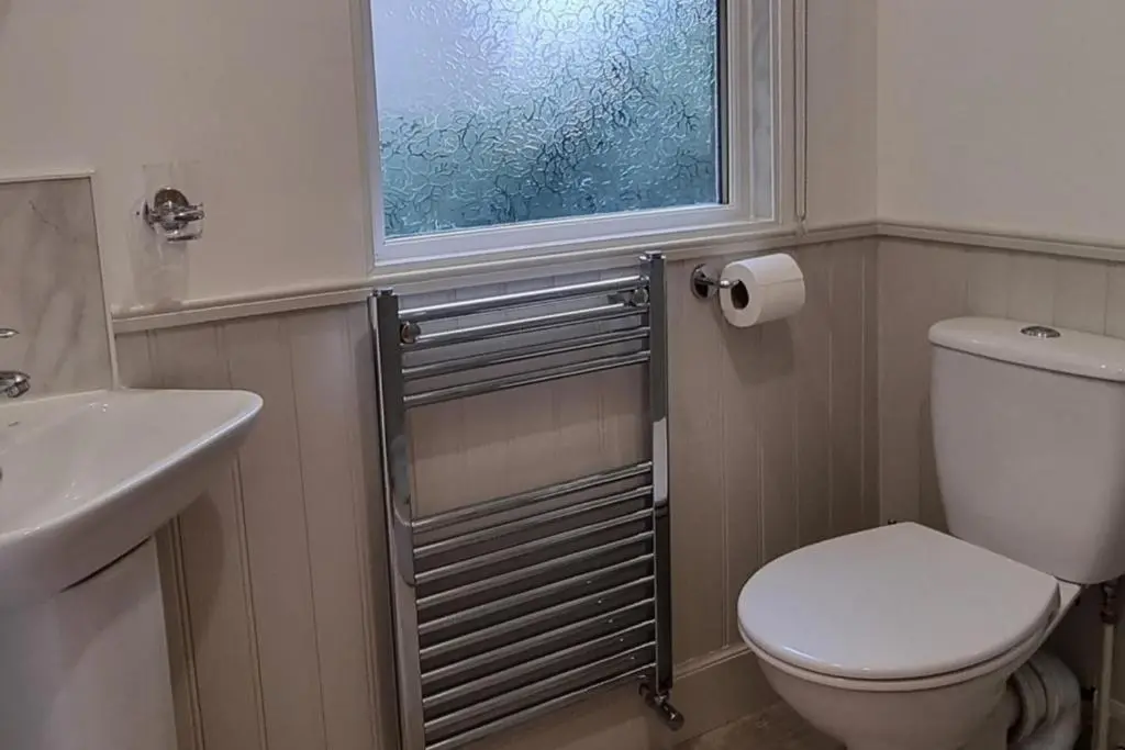 a bathroom with a toilet and a sink and a window at The Coal Office Aberlour in Aberlour