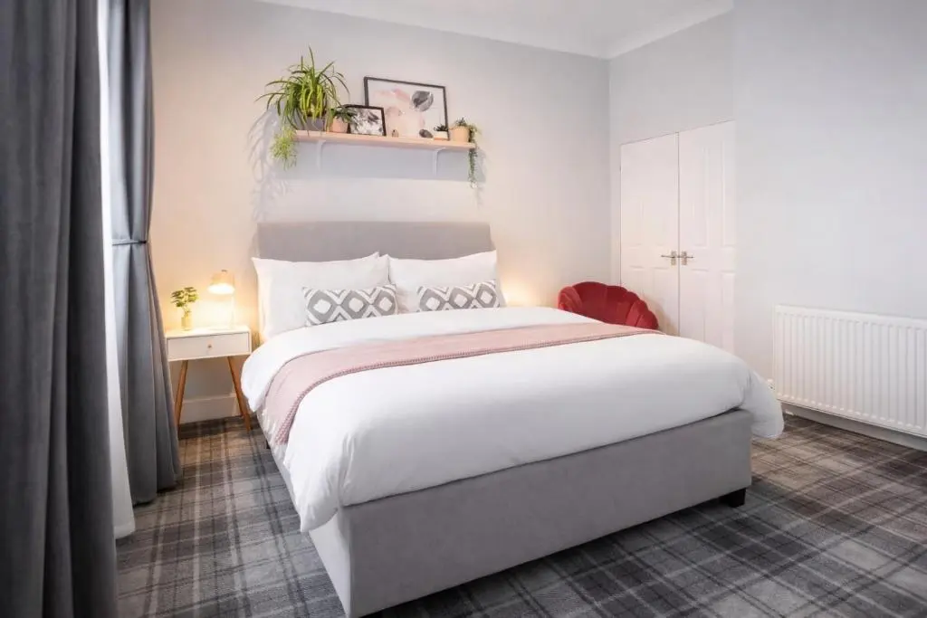 a bedroom with a large white bed in a room at Macdonald Street Snug in Inverness