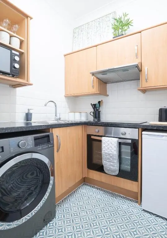 a kitchen with a washer and a dishwasher at Macdonald Street Snug in Inverness
