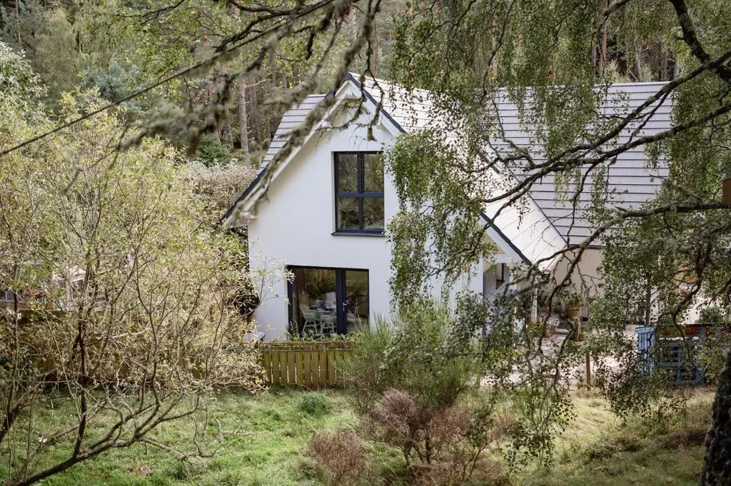 a white house in the middle of a forest at Siskin Guest Suite in Kinrara