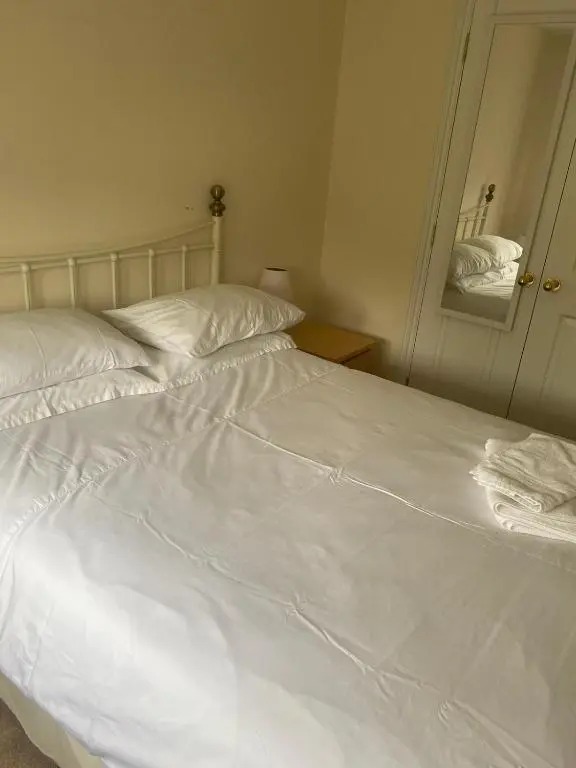 a large white bed in a bedroom with at Kingseat 3 Bed Home With Fast Fibre WiFi &Parking in Newmachar