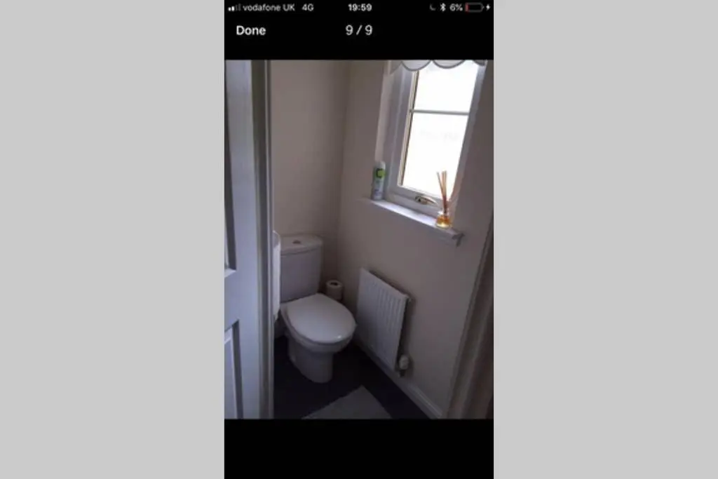 a bathroom with a toilet and a window at Kingseat 3 Bed Home With Fast Fibre WiFi &Parking in Newmachar