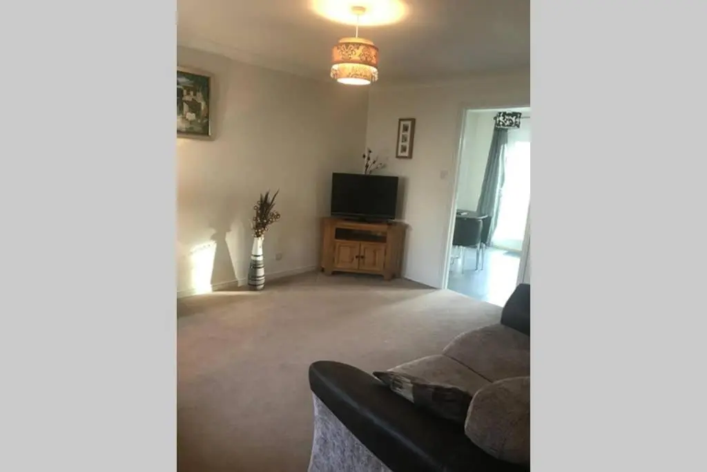 a living room with a couch and a television at Kingseat 3 Bed Home With Fast Fibre WiFi &Parking in Newmachar