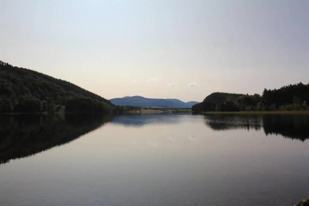 a large body of water with trees and mountains at The One - Chalet in the Cairngorms in Boat of Garten