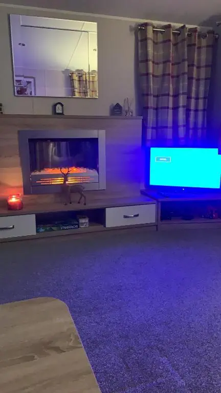 a living room with a flat screen tv and a entertainment center at The One - Chalet in the Cairngorms in Boat of Garten
