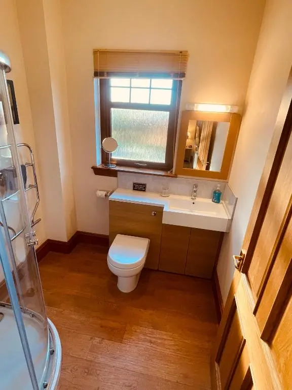 a bathroom with a toilet and a sink and a window at Talisker in Nairn