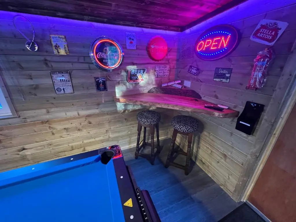 a bar with two stools and a pool table at Royal Snug & Wee Snug Cabins in Kincardine O\u02bcNeil