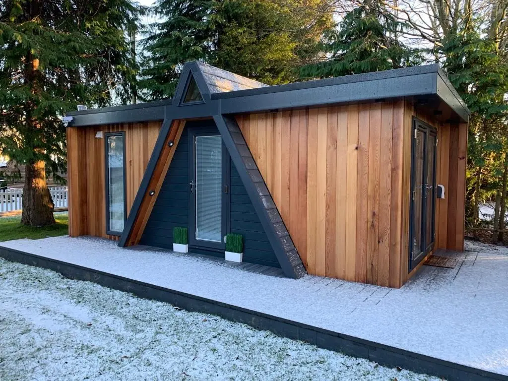 a small cabin with a pitched roof at Royal Snug & Wee Snug Cabins in Kincardine O\u02bcNeil