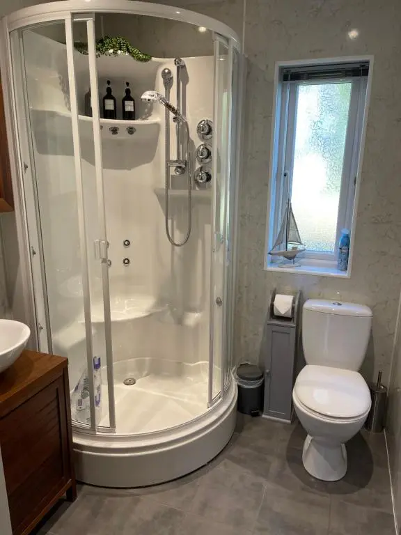 a bathroom with a shower and a toilet at Craigbreck Farm Cottage in North Kessock