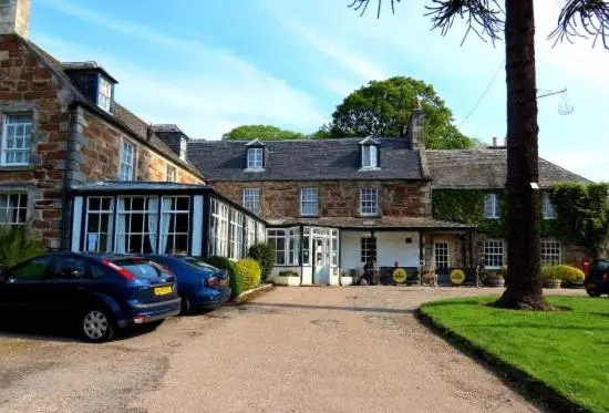 a brick house with cars parked in front of it at Golspie Inn in Backies