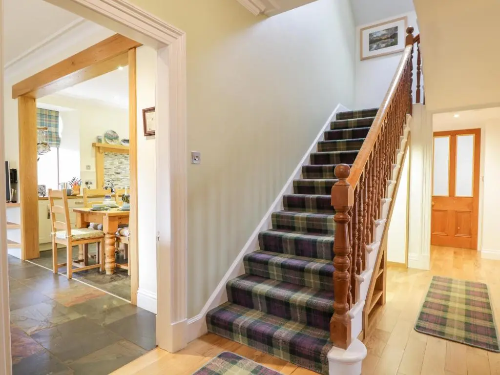 a spiral staircase in a home with a dining room at Orrinside in Muir of Ord