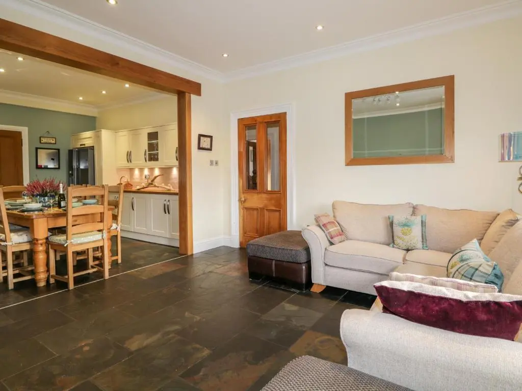 a living room with a couch and a table at Orrinside in Muir of Ord