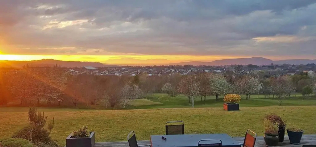 a view of a field with the sunset in the background at Brohar Annexe in Inverness