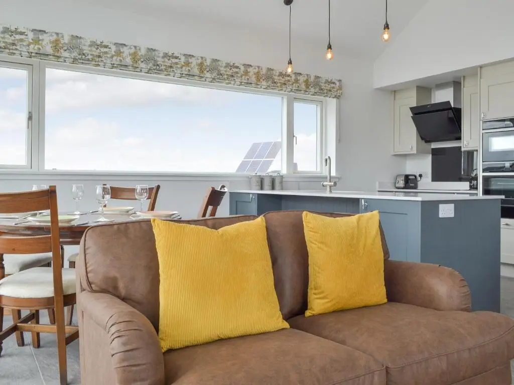 a couch with two yellow pillows in a kitchen at Muirtown Lodge in Keith