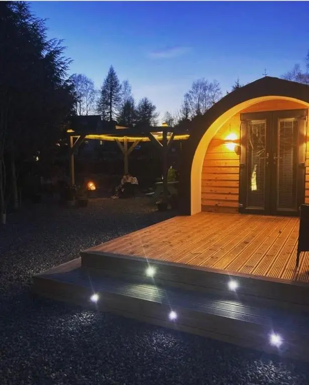 a large wooden deck in front of a cabin at Loch Ness Pods in Fort Augustus