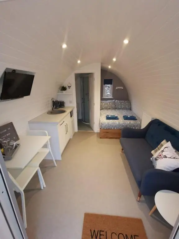 a small living room with a couch and a bed at Loch Ness Pods in Fort Augustus