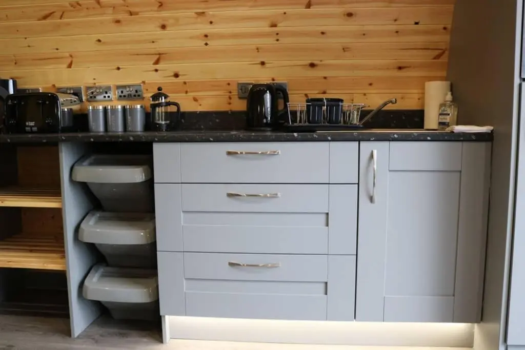 a kitchen with white cabinets and a counter top at Glampods Glamping Pod - meet Highland Cows and Sheep Elgin in Elgin