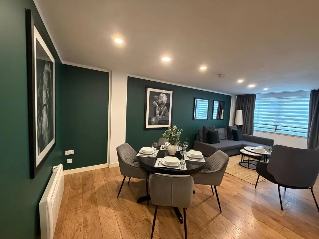 a living room with a table and chairs and a couch at GRAPHITE APARTMENTS in Inverness