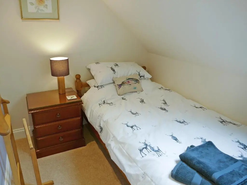 a small bedroom with a bed and a night stand at Easter Lettoch in Advie