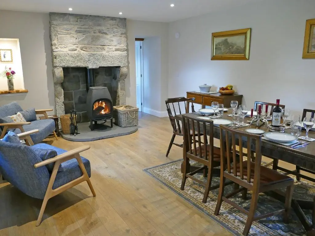 a living room with a table and a fireplace at Easter Lettoch in Advie