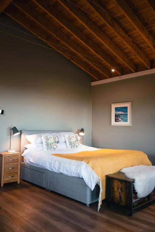 a bedroom with a large bed and a wooden ceiling at The Bothy at Coneloch in Elgin