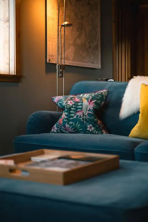 a living room with a blue couch with a pillow at The Bothy at Coneloch in Elgin