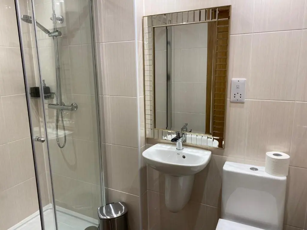 a bathroom with a sink and a shower and a toilet at Waverley Inn Holiday Apartments in Inverness