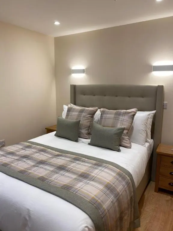 a bedroom with a large bed with two pillows at Waverley Inn Holiday Apartments in Inverness