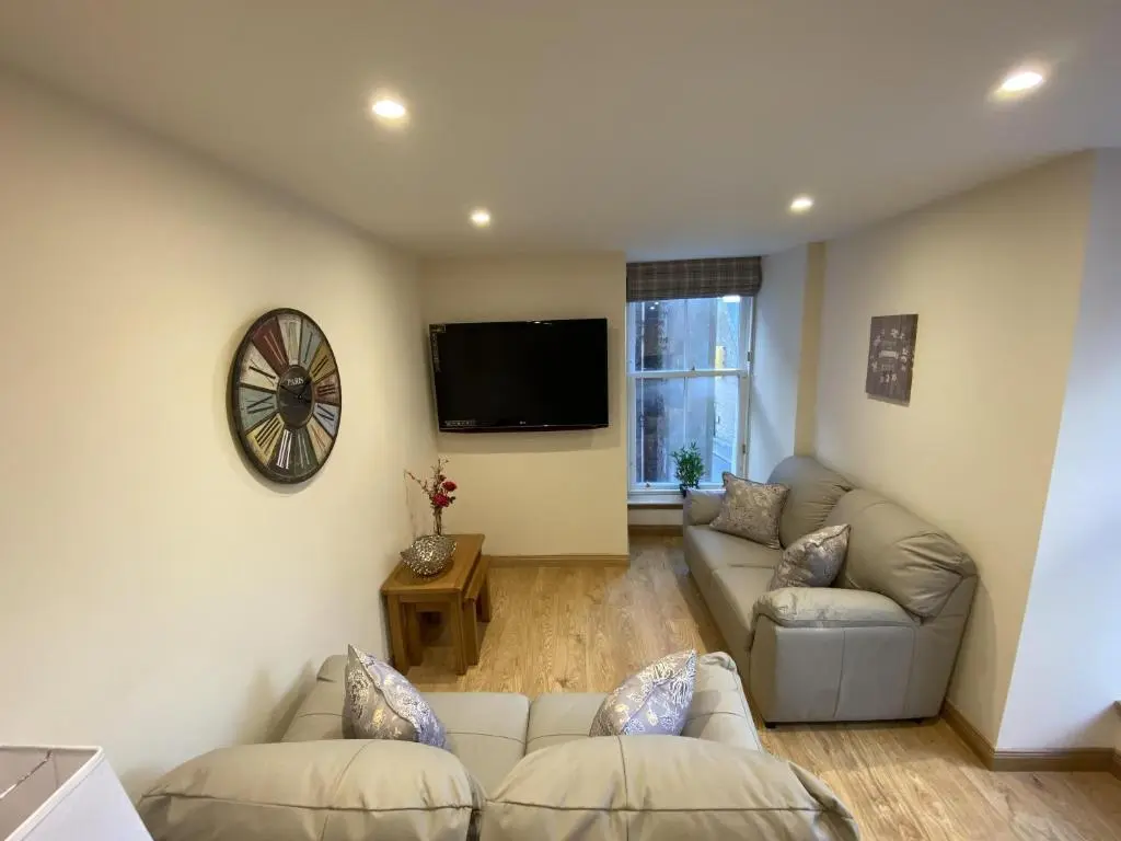a living room with a couch and a tv at Waverley Inn Holiday Apartments in Inverness