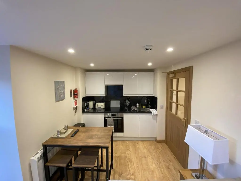 a kitchen with a table and a dining room at Waverley Inn Holiday Apartments in Inverness