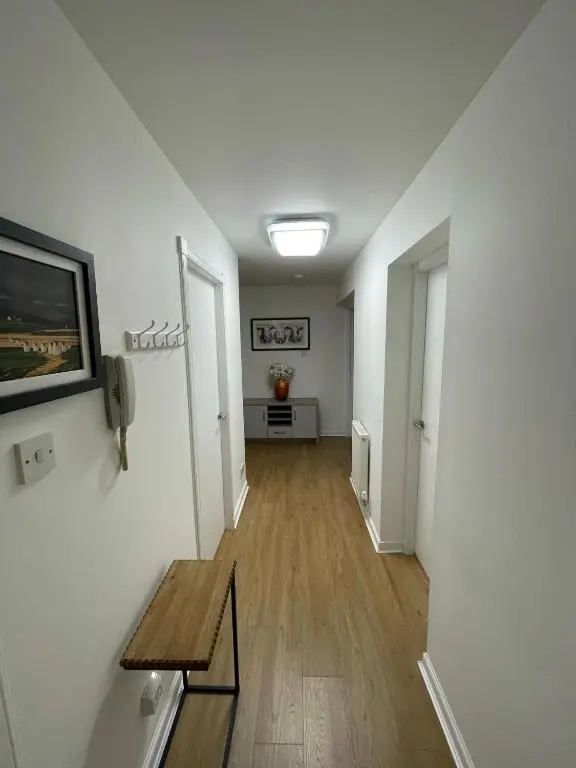 a hallway with a bench and a phone on a wall at Lesmurdie Court, Serviced Accommodation Moray in Elgin