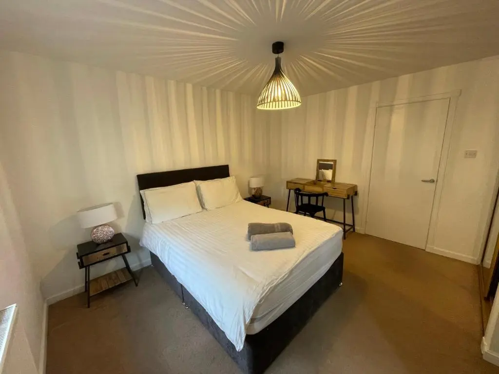 a bedroom with a large bed and a ceiling at Lesmurdie Court, Serviced Accommodation Moray in Elgin