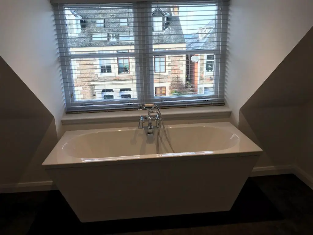 a bath tub in a bathroom with a window at Thistle House in Inverness