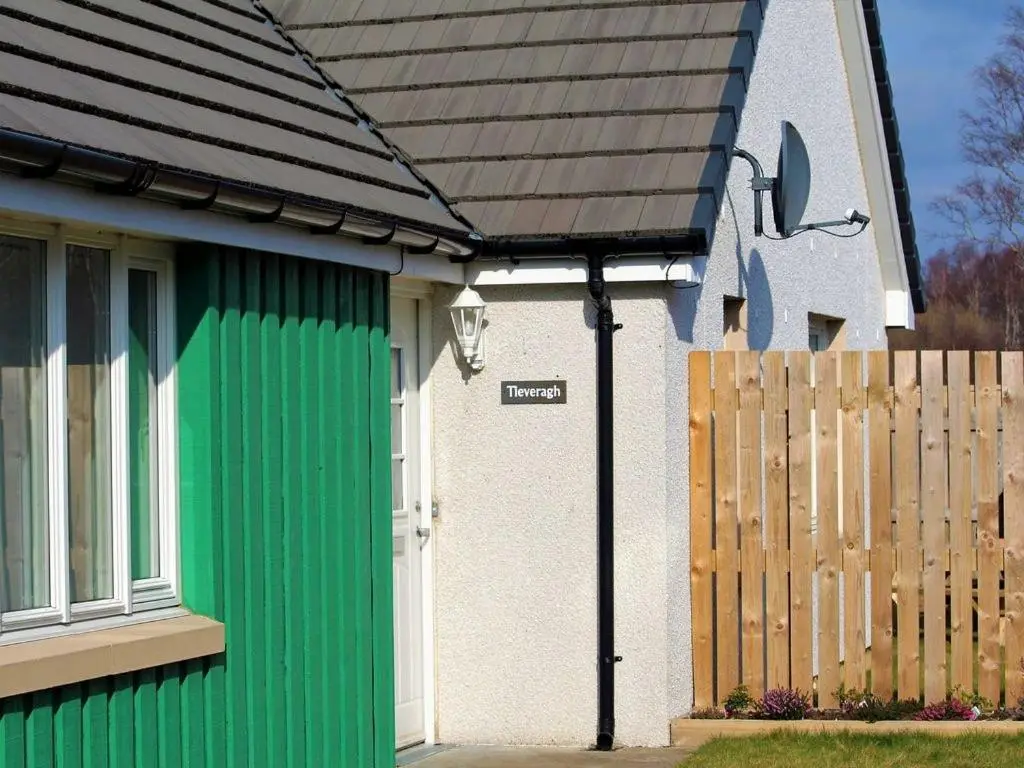 a house with a green door and a fence at Tieveragh in Aviemore