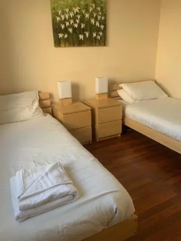 a room with two beds and two night stands with lamps at Tieveragh in Aviemore
