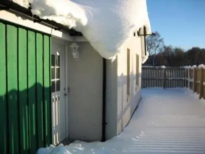 a house with a green gate in the snow at Tieveragh in Aviemore