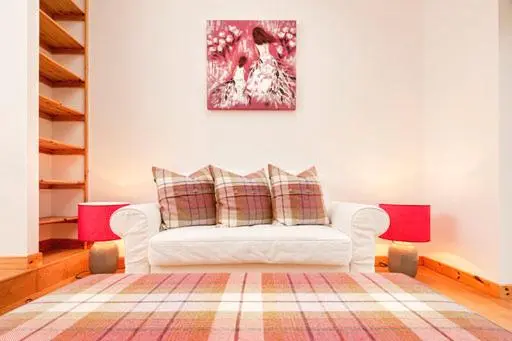 a living room with a white couch and a painting at Balnakyle in Inverness