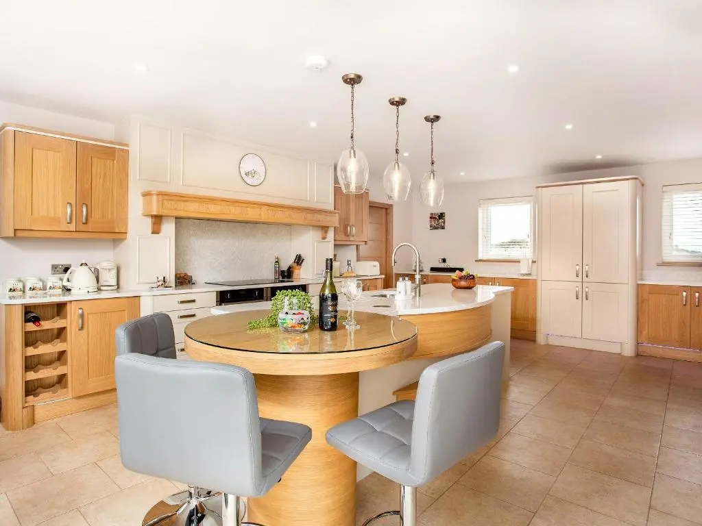 a kitchen with a round wooden table and chairs at Morven View in Dunbeath