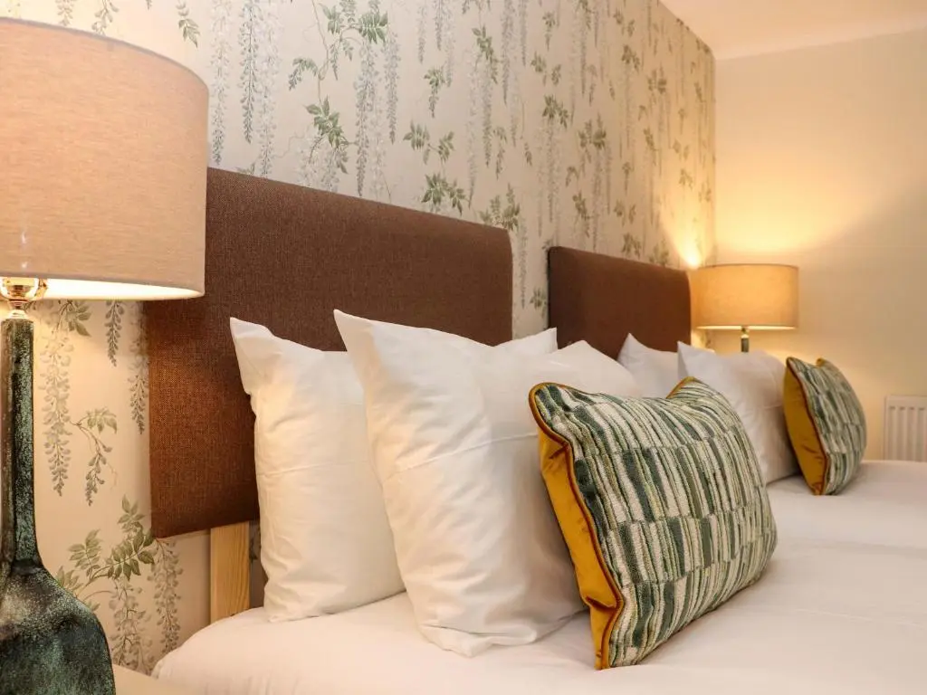a bedroom with a bed with white pillows at Paye House - Cromarty in Cromarty