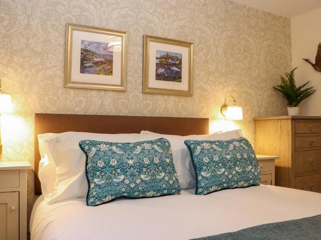 a bedroom with a white bed with two pillows at Paye House - Cromarty in Cromarty