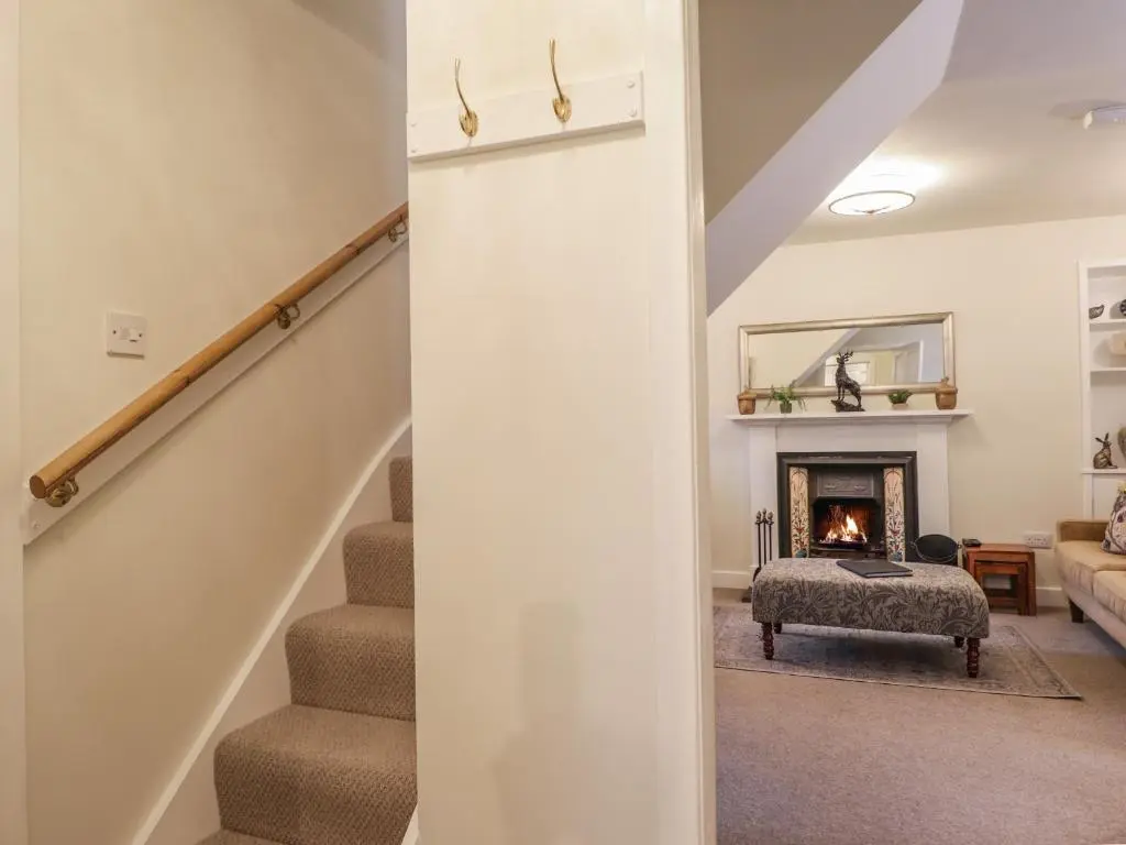 a living room with stairs and a fireplace at Lydia Cottage - Cromarty in Cromarty