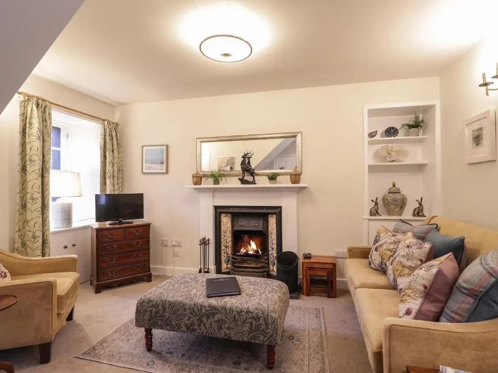 a living room with a couch and a fireplace at Lydia Cottage - Cromarty in Cromarty