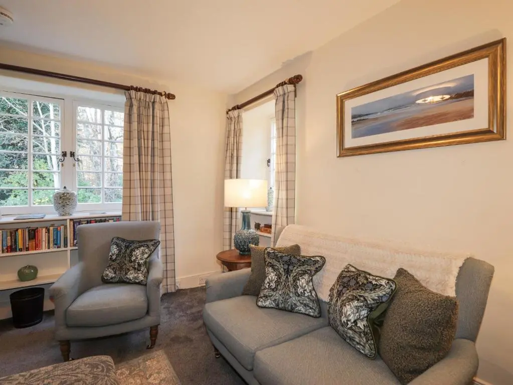 a living room with a couch and a chair at Cormack Lodge - Brodie Castle in Forres
