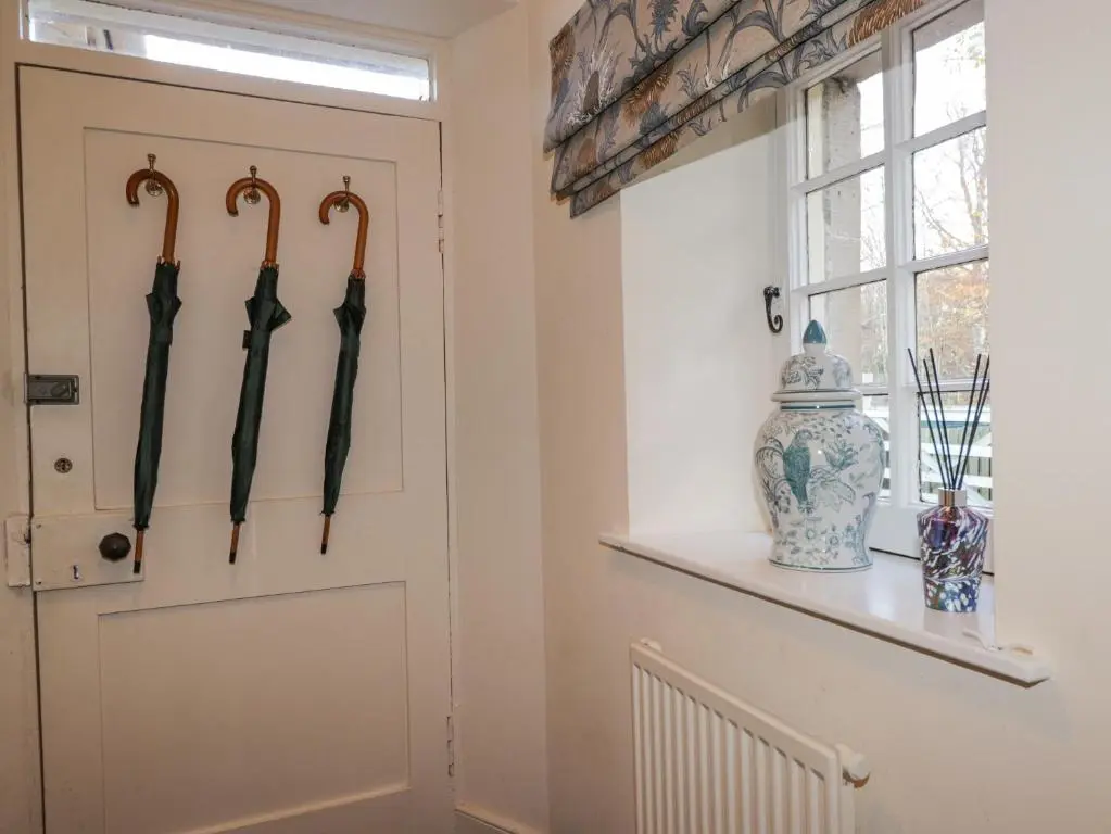 a room with umbrellas hanging on the wall at Cormack Lodge - Brodie Castle in Forres