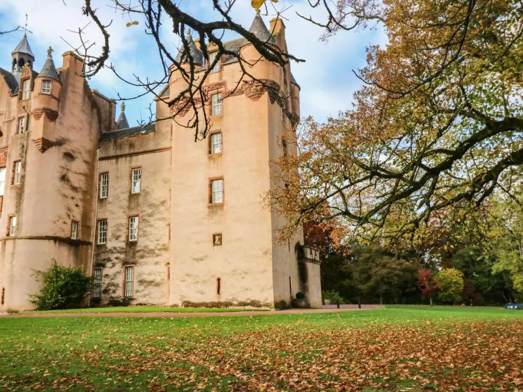 an old castle with leaves on the grass at The Preston Tower Apartment - Fyvie Castle in Turriff