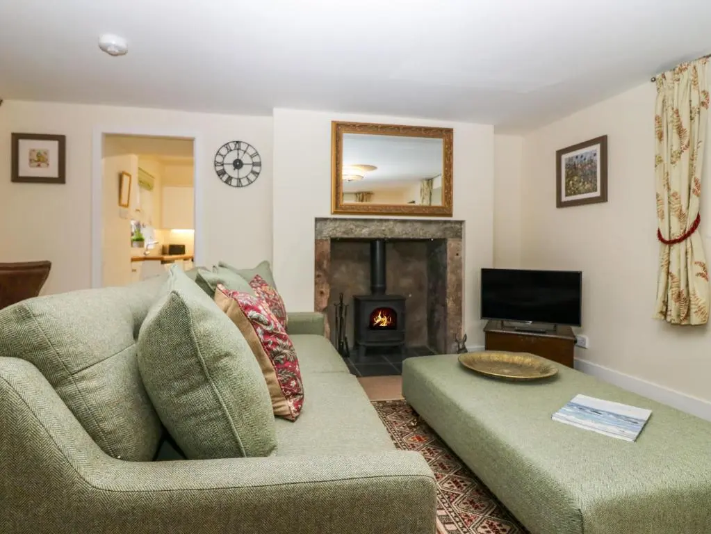 a living room with a couch and a fireplace at North Mains Cottage - Craigievar Castle in Alford
