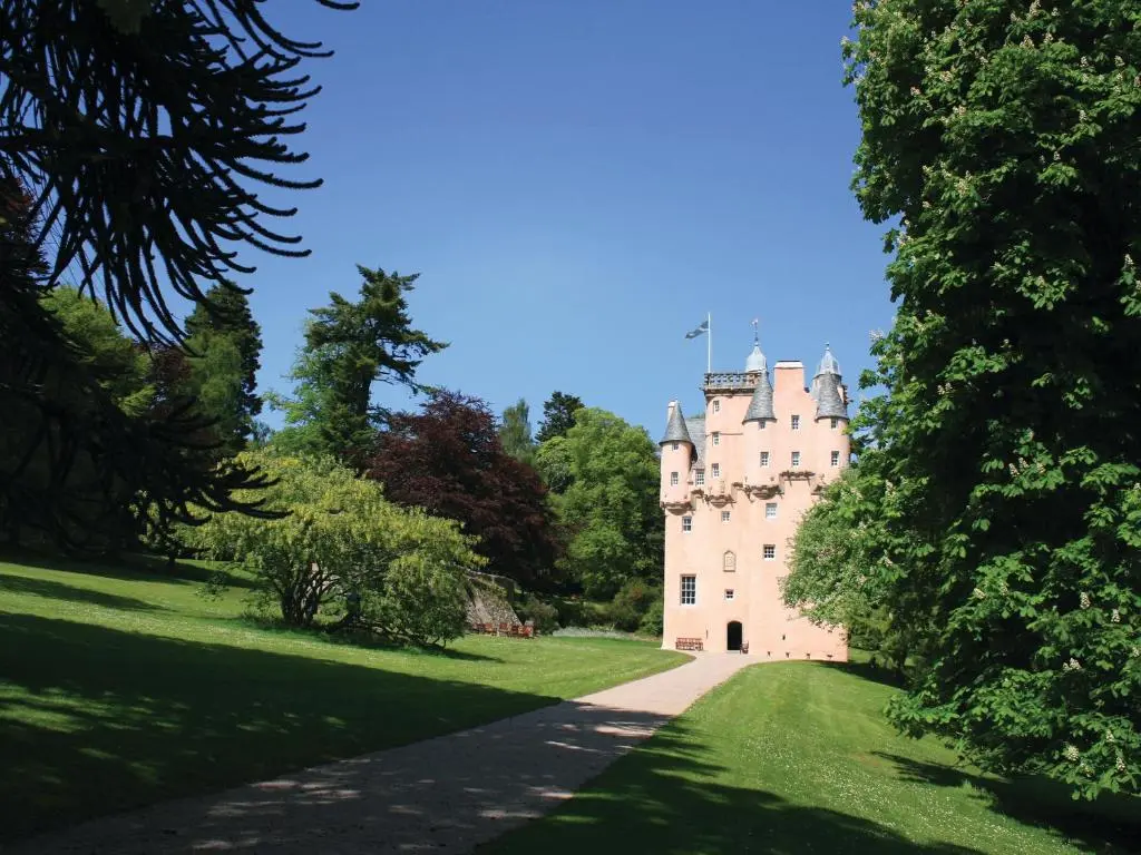 a castle in the middle of a lush green field at North Mains Cottage - Craigievar Castle in Alford