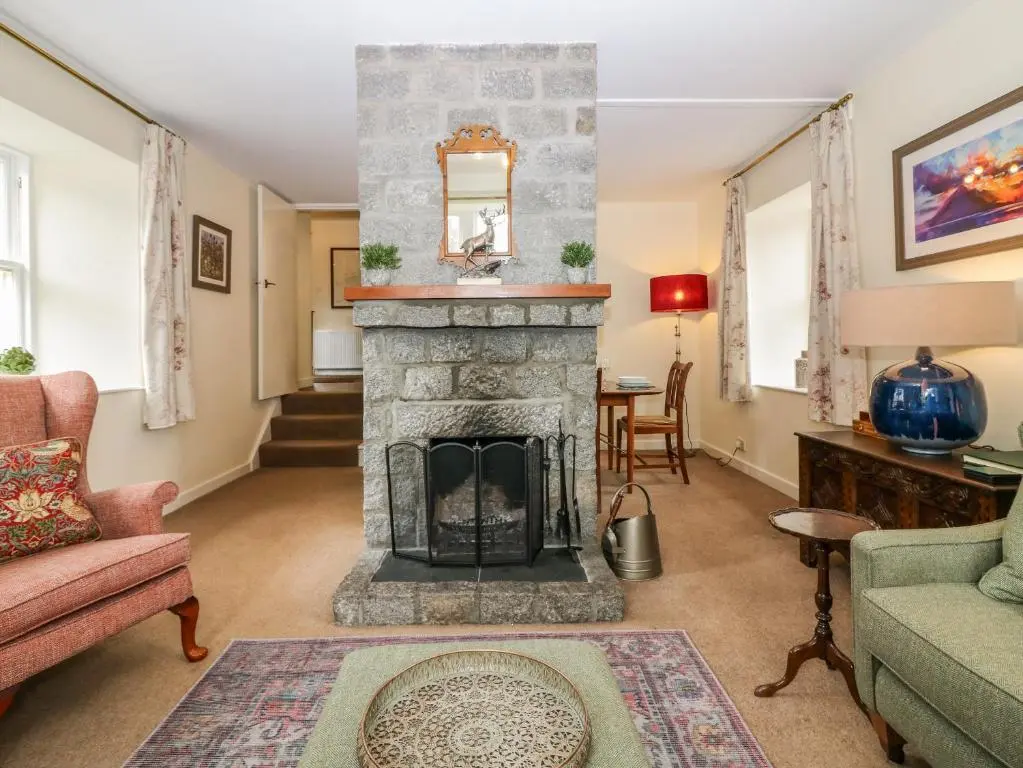 a living room with a stone fireplace at Steading Cottage - Craigievar Castle in Alford