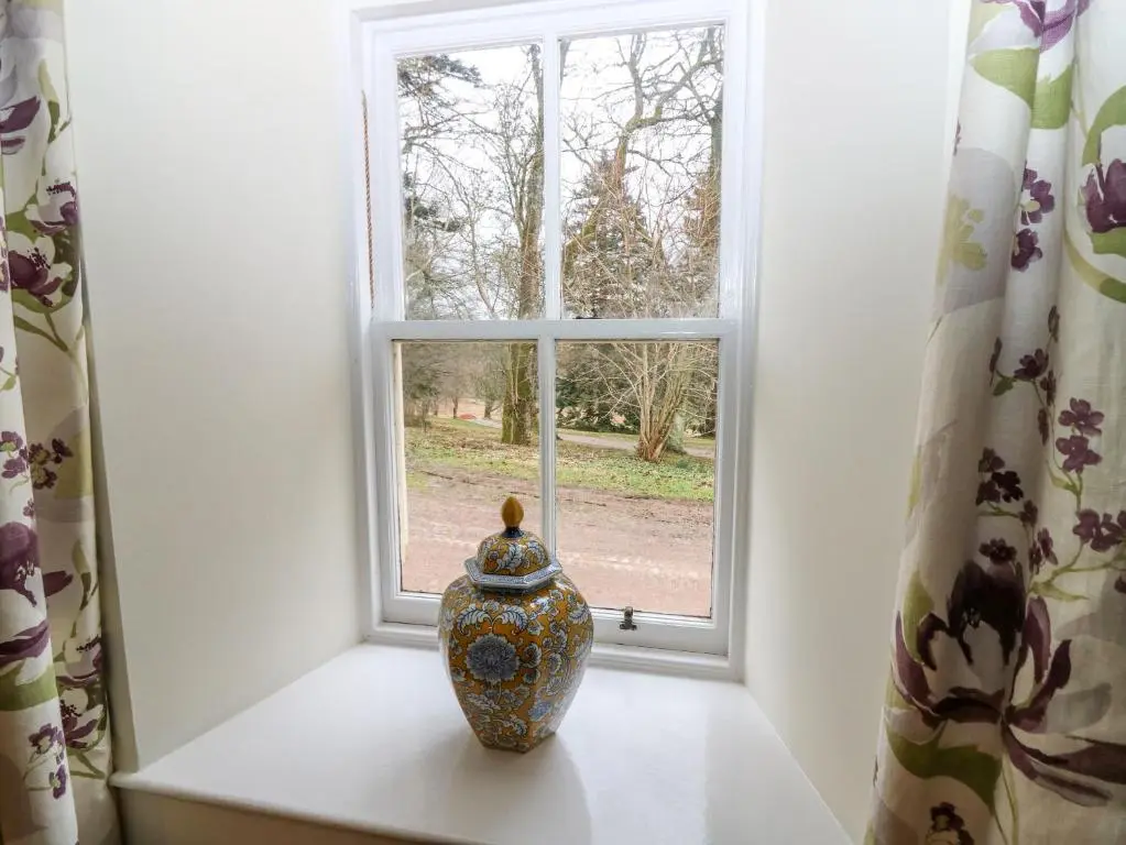 a vase sitting on a window sill in front of a window at Steading Cottage - Craigievar Castle in Alford