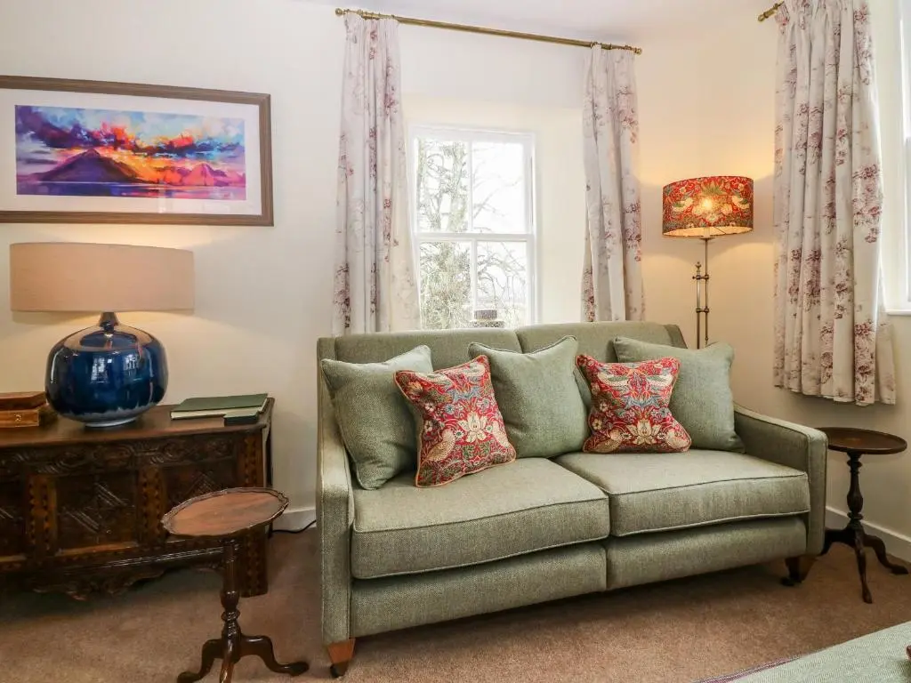 a living room with a couch and a window at Steading Cottage - Craigievar Castle in Alford